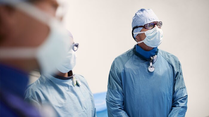 un grupo de médicos con batas quirúrgicas y mascarillas