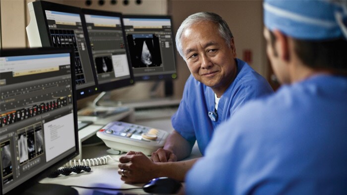 Algunos médicos mirando la pantalla de una computadora.