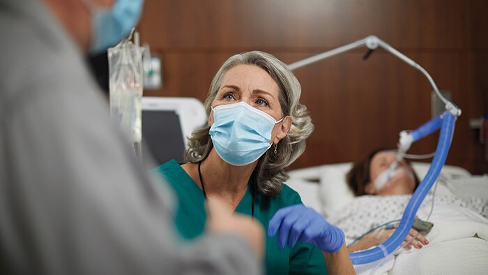 A nurse having a conversation with a physician